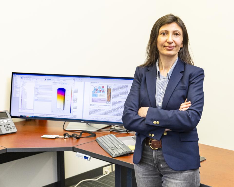 From behind her computer, Canan Karakaya uses modeling to help companies improve chemical reactor design and operation in their industrial facilities. Credit: Carlos Jones/ORNL, U.S. Dept. of Energy 