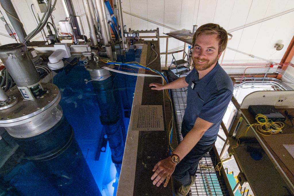 Kyle Reed poses next to the reactor pool at Ohio State.