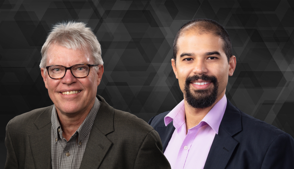 Portrait of two smiling business professionals against a dark geometric background.