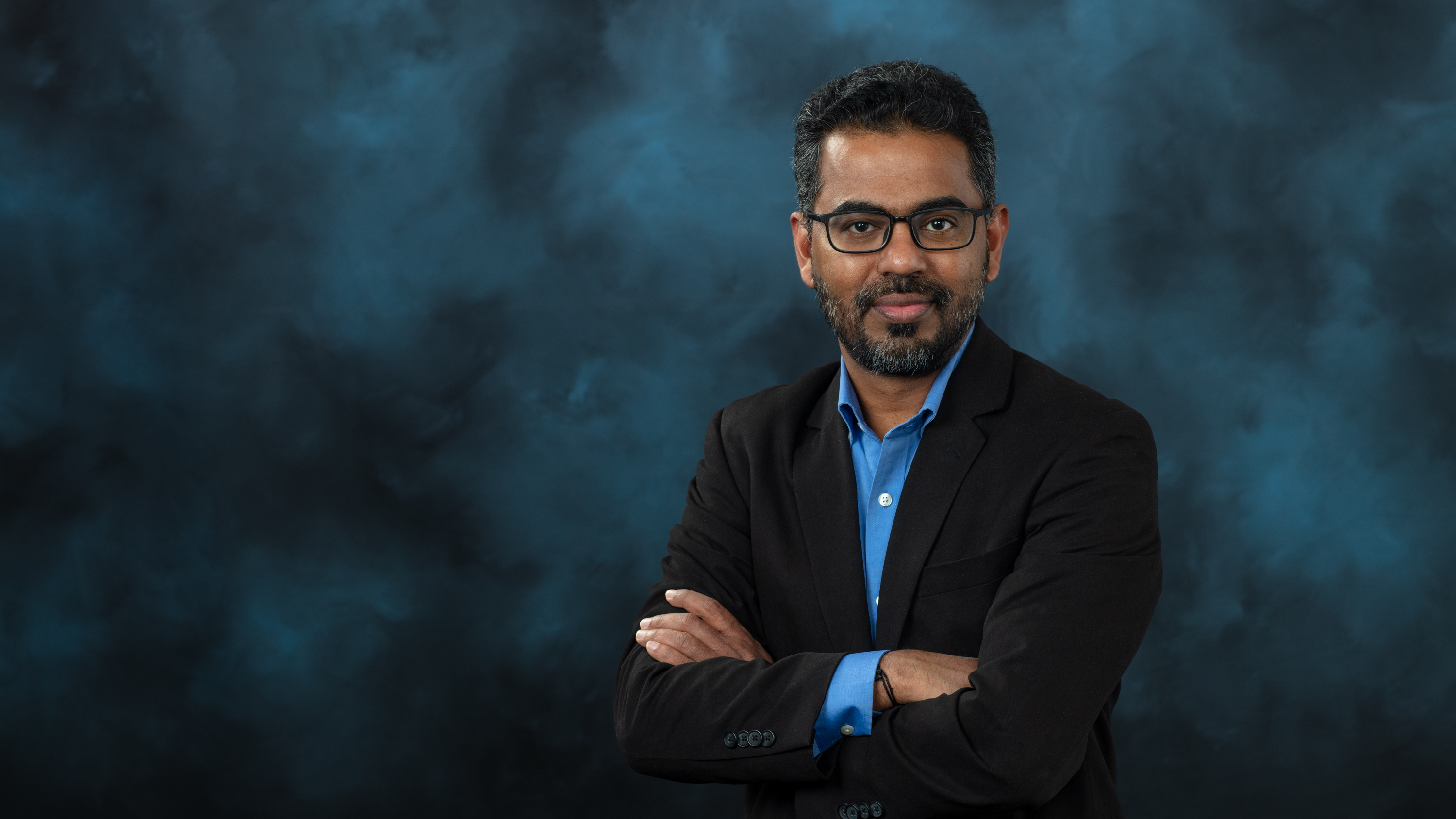 ORNL scientist Prasanna Balaprakash portrait with arms crossed in a suit