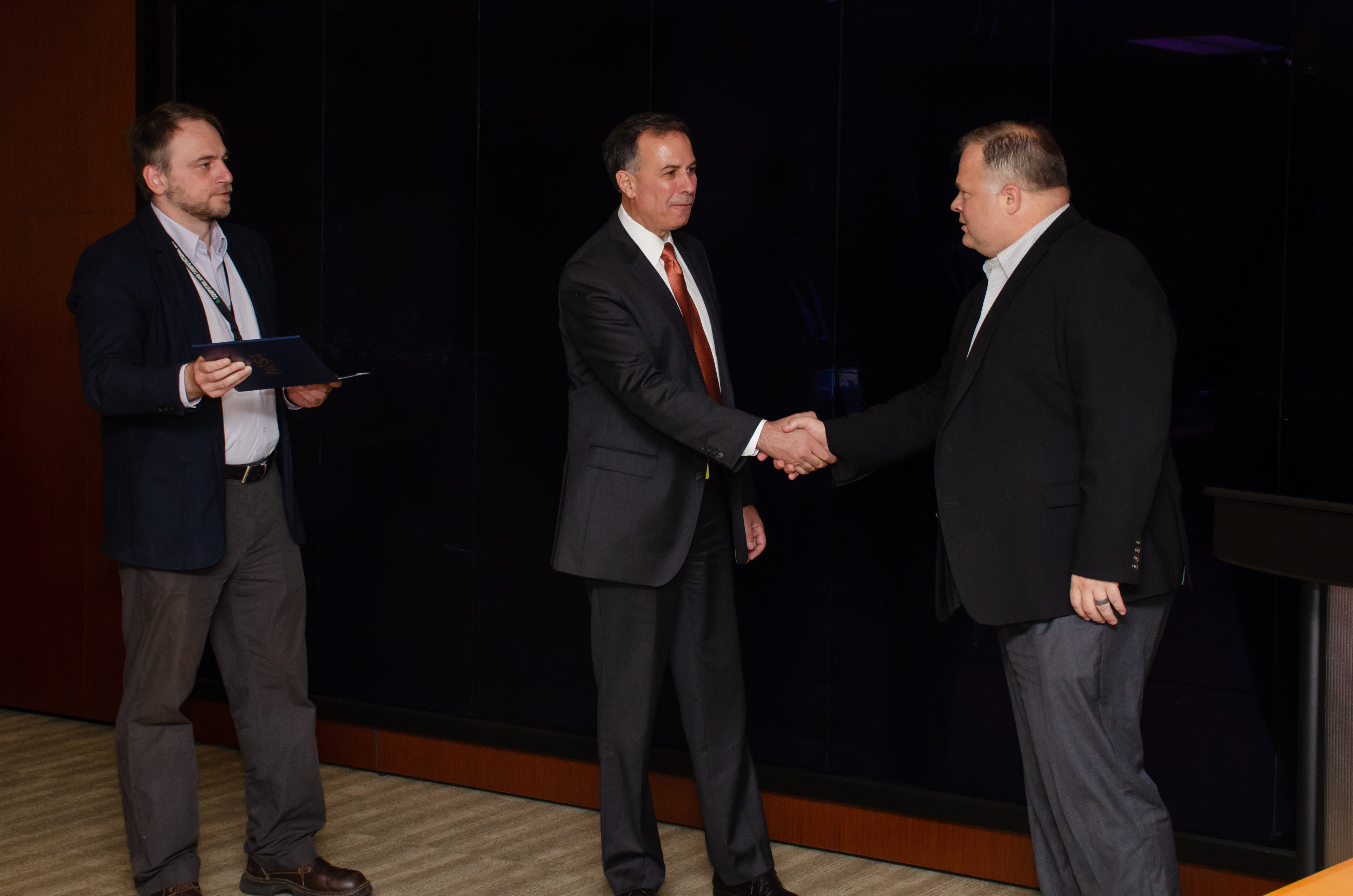 Dr. Dimitri Kusnezov (center), assisted by Edmon Begoli (left), thanks Kris Torgerson, ORNL chief information and privacy officer, for ITSD’s efforts on the MVP-CHAMPION program.