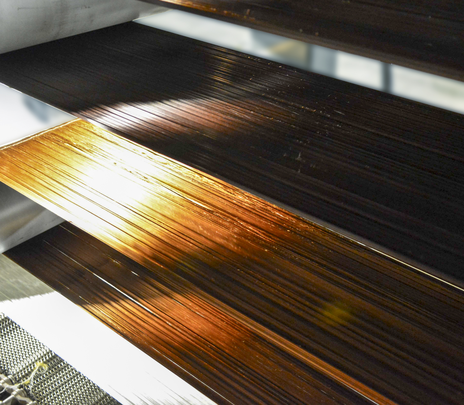 The photo above shows carbon fiber being processed at a much higher throughput than is possible with conventional methods.