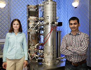 Materials scientists Albina Borisevich, left, Rohan Mishra, and their multi-institutional teammates were the first to discover that in crystals produced from exotic thin films, adding one nonpolar material to another nonpolar material can yield a polar material due to oxygen vacancies. At ORNL, the scientists used CNMS's aberration-corrected scanning transmission electron microscope, pictured here, for imaging and spectroscopy. Photo credit: Jason Richards, ORNL