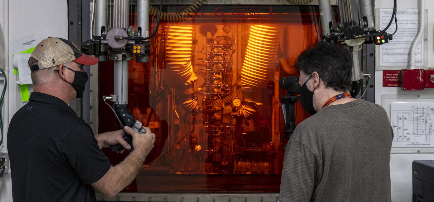Technicians at a hot cell facility in the REDC