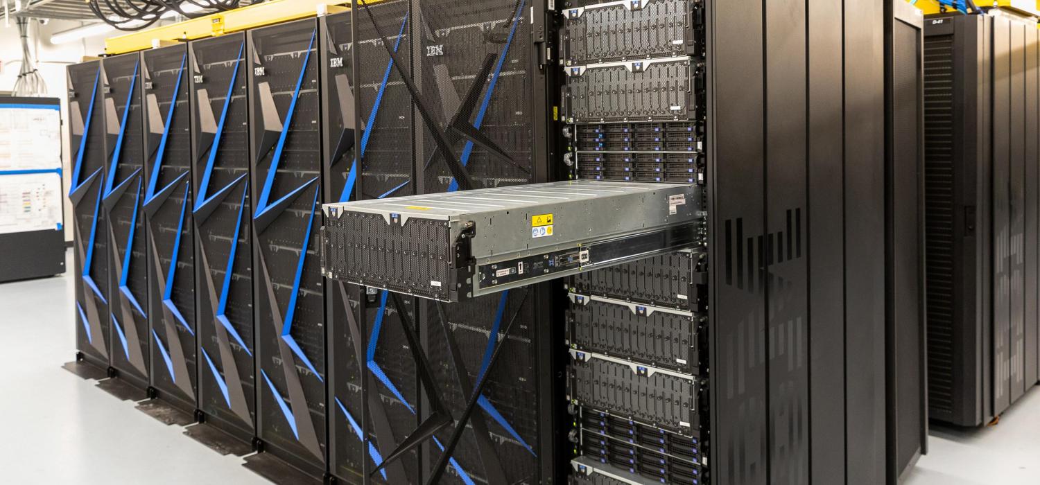 A row of black compute cabinets with a node extended.