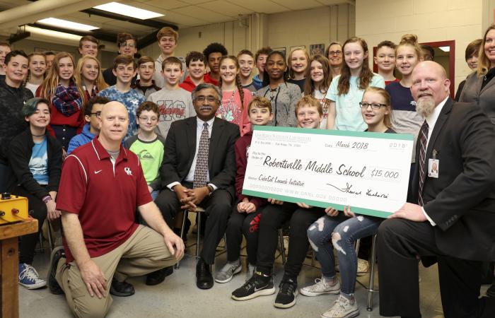 ORNL Director Thomas Zacharia (center, seated) visited Robertsville Middle School to present a check in support of the school’s CubeSat efforts. 