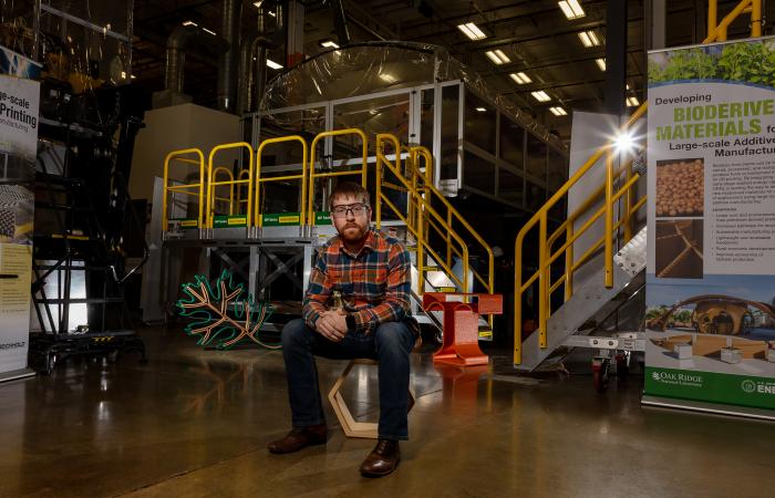 Alex Roschli, sitting in front of large-scale 3D printer