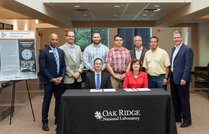 Seated from left is Lou Santodonato, ARS co-president, and Michelle Buchanan, ORNL deputy director, who signed the technology licensing agreement for ORNL’s liquid helium auto-fill technology. Standing from left is Michael Holmes, ARS co-president; Eugene Cochran, ORNL senior commercialization manager; Ryan Morgan, Mariano Ruiz-Rodriguez, Chris Redmon and Saad Elorfi, ORNL inventors; and Mike Paulus, ORNL technology transfer director.