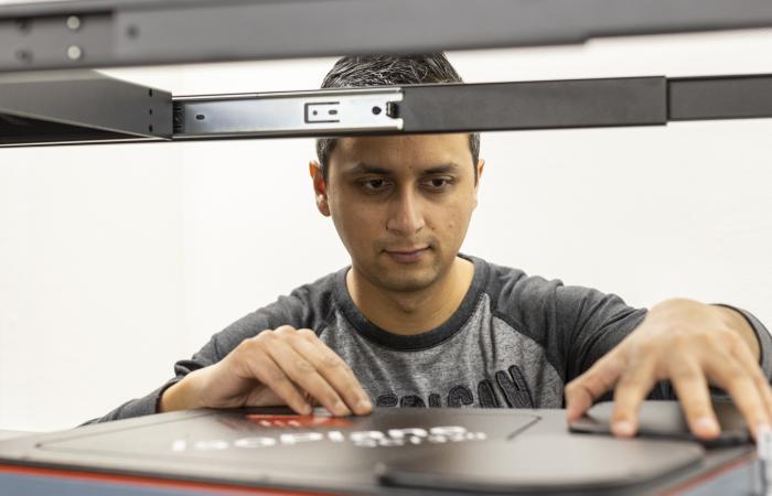 Postdoctoral researcher Nischal Kafle positions a component for a portable plasma imaging diagnostic device at ORNL in February. The device, a project for ARPA-E, is built of off-the-shelf parts. Credit: Carlos Jones/ORNL