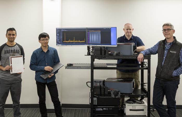 From left, postdoctoral researcher Nischal Kafle, UT graduate student Zichen “Horus” He, instrumentation specialist Wayne Garren, and principal investigator Theodore Biewer of ORNL’s Fusion Energy Division stand with a portable plasma diagnostic imaging device they built. (Not pictured is R&D staff member Drew Elliott.) After the team adds a laser, the device will be ready for testing at ORNL before being taken to other experimental plasma sources this summer and fall. Credit: Carlos Jones/ORNL