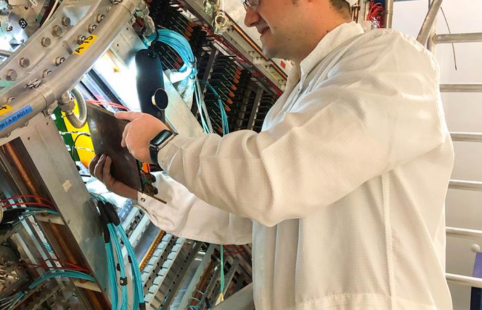 ORNL electronics engineer Alex Rusu performs installation steps on the Time Projection Chamber in the clean room at the ALICE site. Oak Ridge National Laboratory, U.S. Dept. of Energy