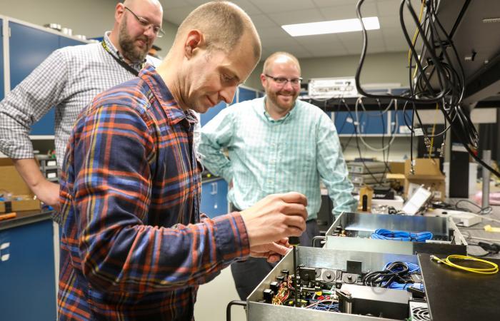 Three ORNL researchers working in a lab. 