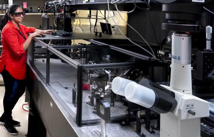 Postdoctoral research associate Uvinduni Premadasa stands beside the microscopy tool, which captures wide-field images of biological samples with chemical detail. Credit: Carlos Jones/ORNL, U.S. Dept. of Energy  