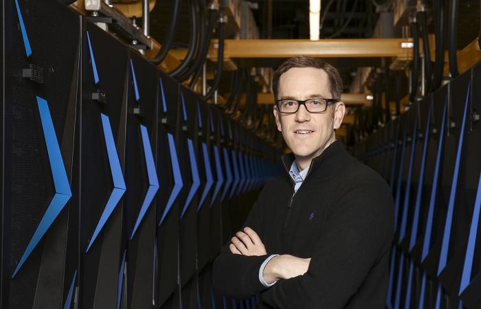 Paul Kent, shown above posing with Summit in April 2018, received the 2020 ORNL Director's Award for Outstanding Individual Accomplishment in Science and Technology. Credit: ORNL, U.S. Dept. of Energy