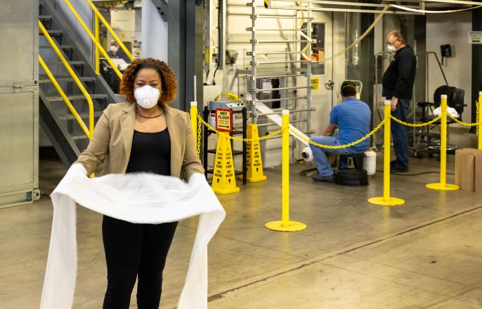 Merlin Theodore, with the N95 filter material at DOE’s Carbon Fiber Technology Facility at ORNL, collaborated with the research team that developed the process for converting melt-spinning capabilities into the production of polypropylene. The innovation, which was transferred to industry for the mass production of N95 masks and material, was honored with a 2021 FLC Impact award. Credit: ORNL, U.S. Dept of Energy