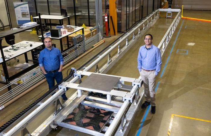 L-R: ORNL’s Omer Onar and Veda Galigekere with the dynamic wireless charging test bed at ORNL’s Grid Research Integration and Deployment Center. Credit: Carlos Jones, ORNL/U.S. Dept. of Energy