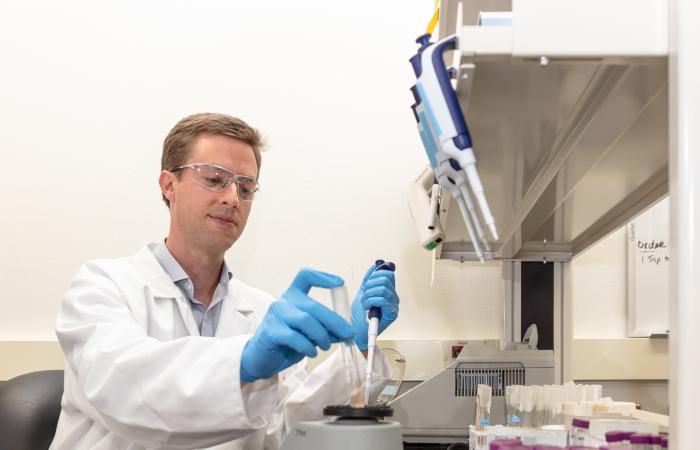 ORNL’s Josh Michener, a microbiologist and metabolic engineer, led the discovery of a useful new enzyme that breaks down stubborn bonds in lignin, a polymer found in plants that typically becomes waste during bioconversion. Credit: Carlos Jones/ORNL, U.S. Dept. of Energy