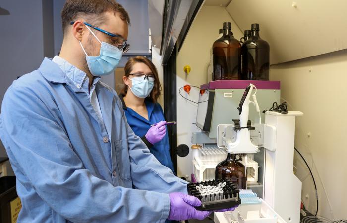 Jansone-Popova, right, uses an automated chromatography system to purify diglycolamide — an extractant used for rare-earth element separation. Popovs prepares samples for the analysis using a pipetting robot. Credit: Genevieve Martin/ORNL, U.S. Dept. of Energy 
