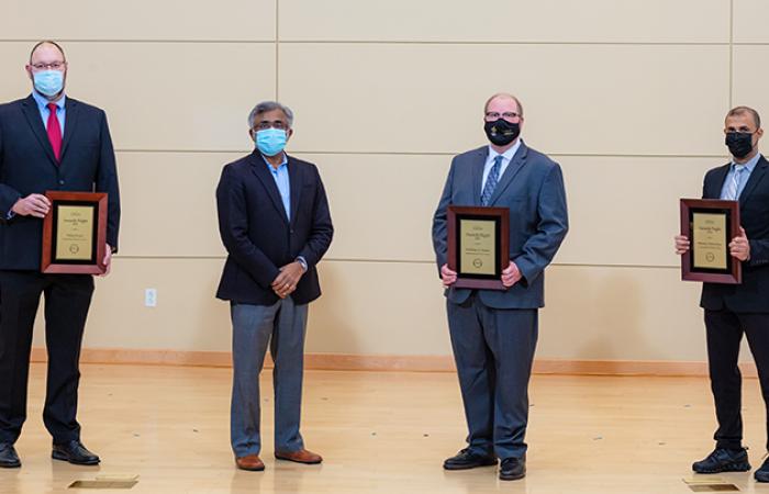 ORNL Director Thomas Zacharia, second from left, presents Phil Evans, left, Nicholas Peters, second from right, and Muneer Alshowkan with plaques for the winning the 2021 Director's Award for Outstanding Team Accomplishment in Science and Technology on Dec. 10, 2021. Credit: Carlos Jones/ORNL, U.S. Dept. of Energy