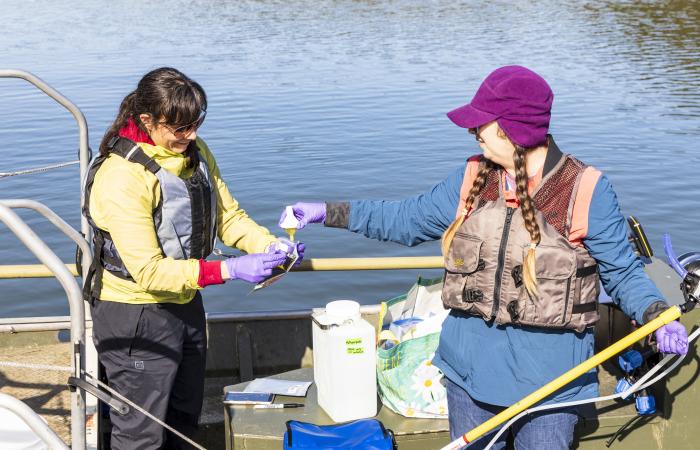 ORNL’s Brenda Pracheil, left, and Kristine Moody collect water samples at Melton Hill Lake using a sophisticated instrument that collects DNA in the water to determine fish species and number of fish in the water, which could prove useful for monitoring hydropower impacts. Credit: Carlos Jones, ORNL/U.S Dept. of Energy
