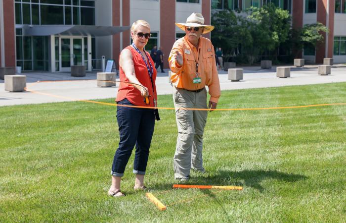 Kathy McCarthy, associate laboratory director for the Fusion and Fission Energy and Science Directorate, practices casting with Project Healing Waters Fly Fishing volunteer Bob Stephan during the directorate's ORNL Gives fundraising event, the Fish, Fetch and Fly Festival, on the ORNL quad on June 30, 2021. Credit: Genevieve Martin/ORNL, U.S. Dept. of Energy