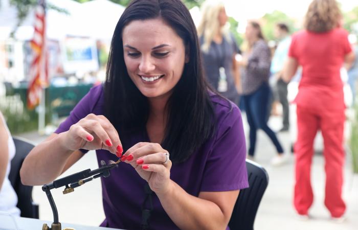 Regina Woodward tries her hand at fly-tying during the Fish, Fetch and Fly Festival on the ORNL quad on June 30, 2021. Credit: Genevieve Martin/ORNL, U.S. Dept. of Energy