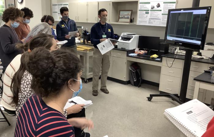 University of Michigan students review data together on a tv screen