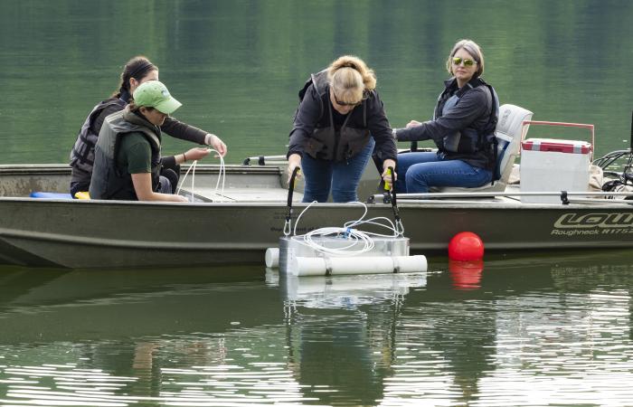 The research team deploys a dome that measures greenhouse gases that are emitted from the reservoir water surface via diffusion. Credit: Carlos Jones/ORNL, US Dept. of Energy