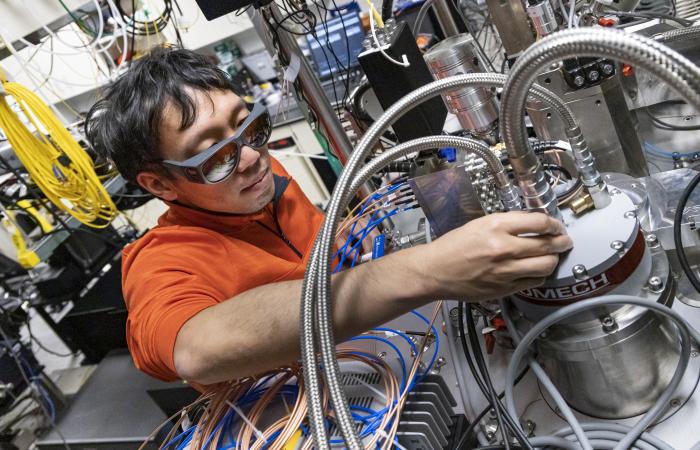 Yun-Yi Pai works with a closed-cycle dilution refrigerator designed for cryomagnetooptical microscopy at ORNL. Credit: Carlos Jones/ORNL, U.S. Dept. of Energy 