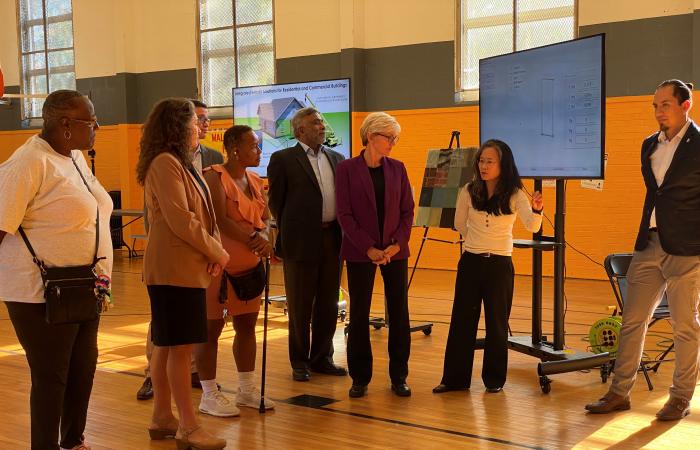 Community members listened to ORNL scientist Diana Hun, second from right, explain the benefits of overclad panel technologies to improve energy efficiency of public housing to Energy Secretary Jennifer Granholm and ORNL Director Thomas Zacharia. Hun and colleagues demonstrated the technology at the Western Heights Boys and Girls Club in Knoxville, Tenn. Credit: Jenny Woodbery/ORNL, U.S. Dept. of Energy