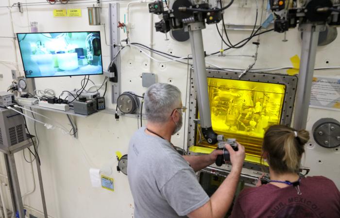 Experts in the Radiochemical Engineering and Development Center, or REDC, use manipulators to work with radioactive actinium-225 that is safely encased in a hot cell. The REDC complex has 16 hot cells that allow scientists to safely handle radioactive materials. Ac-225 is an in-demand isotope because of its potential for treating cancers. Credit: Genevieve Martin, ORNL/U.S. Dept. of Energy
