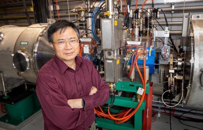 ORNL’s Yun Liu stands before one of the 10 laser comb-based beam diagnostics stations at the Spallation Neutron Source. The laser comb solves the longstanding problem of measuring changes in the beam across time. Credit: Genevieve Martin/ORNL, U.S. Dept. of Energy