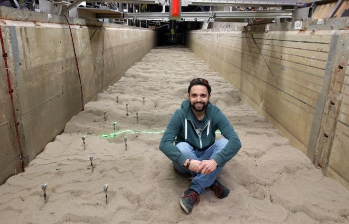 Mirko Musa studies how hydrokinetic turbines, akin to underwater wind turbines, might impact riverbed vegetation or the way sediment flows downriver. Here, he’s sitting inside a mock sandy river channel. Credit: Mirko Musa/ORNL, U.S. Dept. of Energy