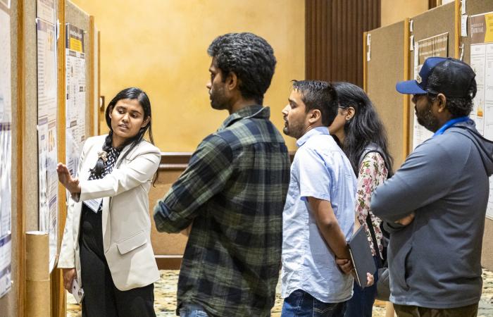 Chathuddasie Amarasinghe explains her research poster, “Using Microfluidic Mother Machine Devices to Study the Correlated Dynamics of Ribosomes and Chromosomes in Escherichia Coli.” Credit: Carlos Jones/ORNL, U.S. Dept. of Energy