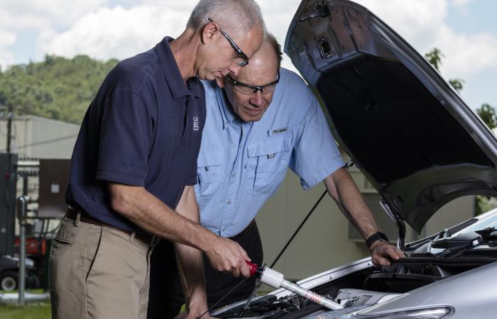 L-R, Nance Ericson, Bruce Warmack test the Hot Stick on a hybrid electric vehicle (ORNL photographer Carlos Jones).