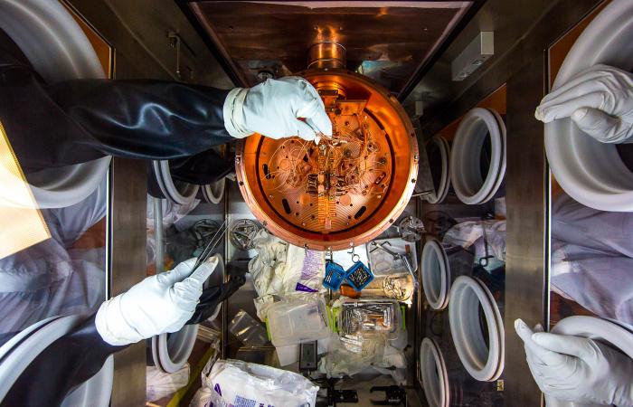 Researchers work on the delicate wiring of a cryostat, which is like a thermos under vacuum that chills the detectors that are the heart of the MAJORANA DEMONSTRATOR. The experiment’s 2 cryostats each house 29 germanium detectors—diodes that are reverse b