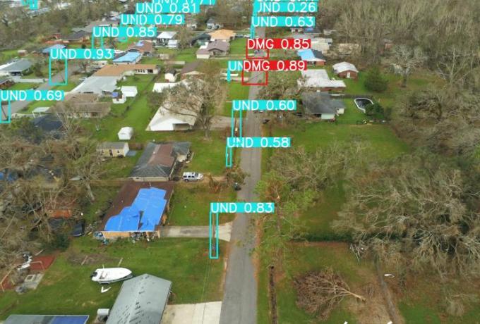 Aerial drone picture showing a scan of an urban street. Tags on the picture show where utility poles are and show green for undamaged and red for damaged.
