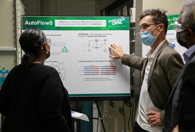 Dr Berhe standing in front of scientific poster