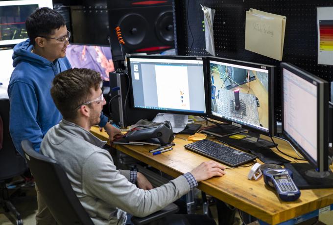 two researchers work together in front of a computer
