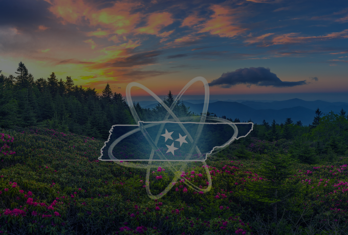 Sunset over a scenic mountain landscape with vibrant pink flowers in the foreground and evergreen trees in the distance. Overlay of an atomic symbol and a Tennessee state outline with three stars in the center.