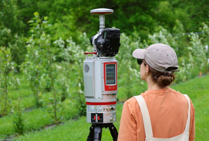 researcher taking lidar measurements in a field