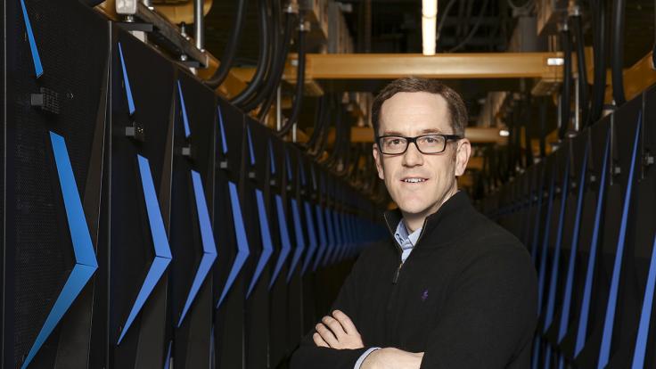 Paul Kent, shown above posing with Summit in April 2018, received the 2020 ORNL Director’s Award for Outstanding Individual Accomplishment in Science and Technology. Credit: ORNL, U.S. Dept. of Energy