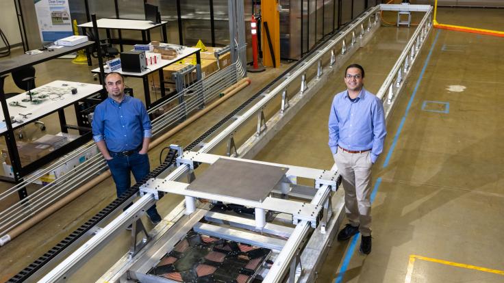 L-R: ORNL’s Omer Onar and Veda Galigekere with the dynamic wireless charging test bed at ORNL’s Grid Research Integration and Deployment Center. Credit: Carlos Jones, ORNL/U.S. Dept. of Energy