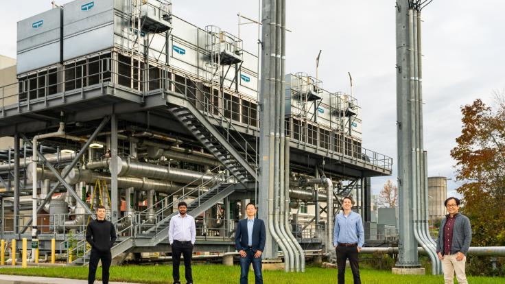 Five men stand in front of Summit's cooling towers