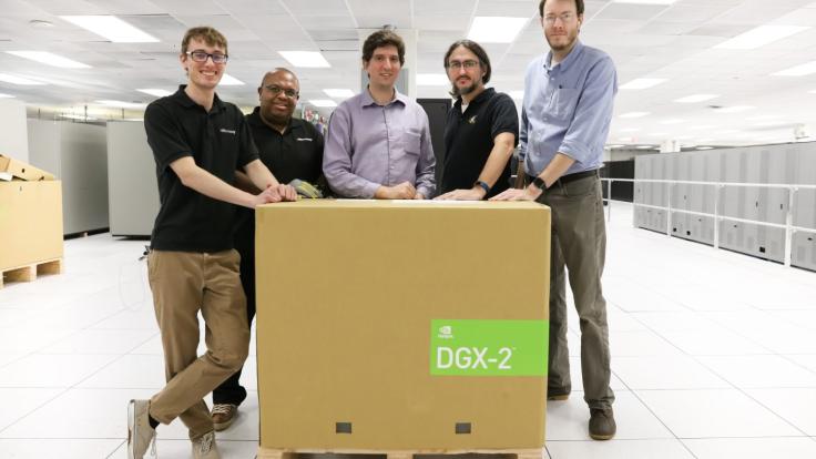 Five men standing behind a large box