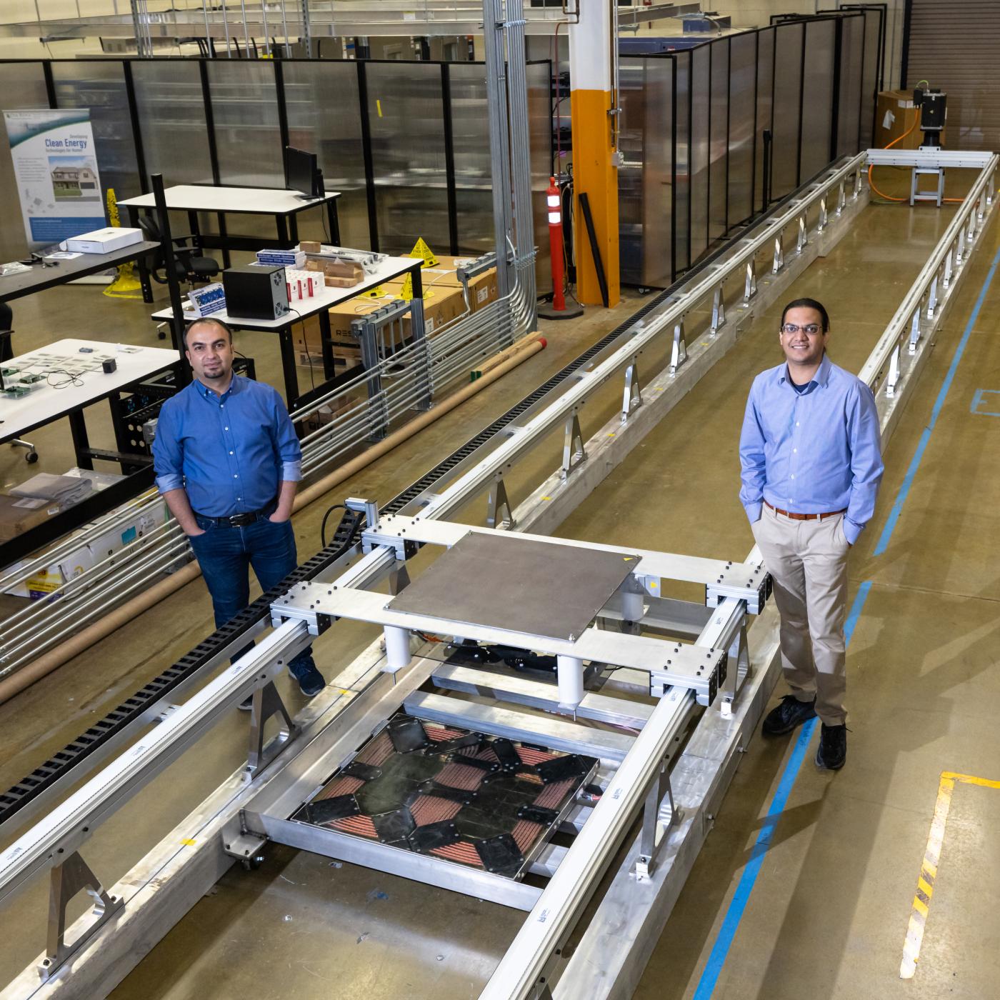 L-R: ORNL’s Omer Onar and Veda Galigekere with the dynamic wireless charging test bed at ORNL’s Grid Research Integration and Deployment Center. Credit: Carlos Jones, ORNL/U.S. Dept. of Energy