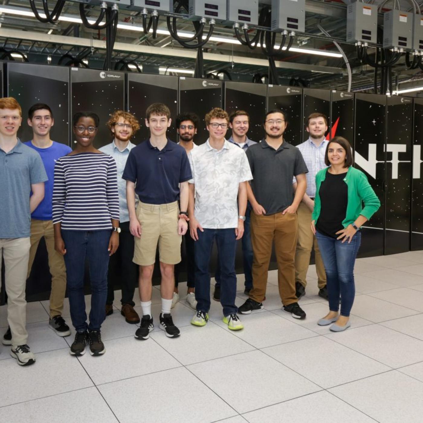 Group of people standing in front of Frontier supercomputer