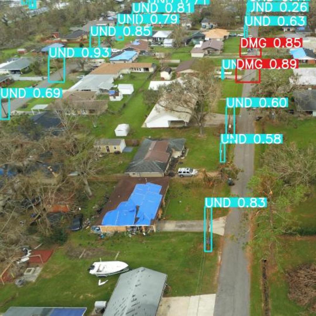 Aerial drone picture showing a scan of an urban street. Tags on the picture show where utility poles are and show green for undamaged and red for damaged.