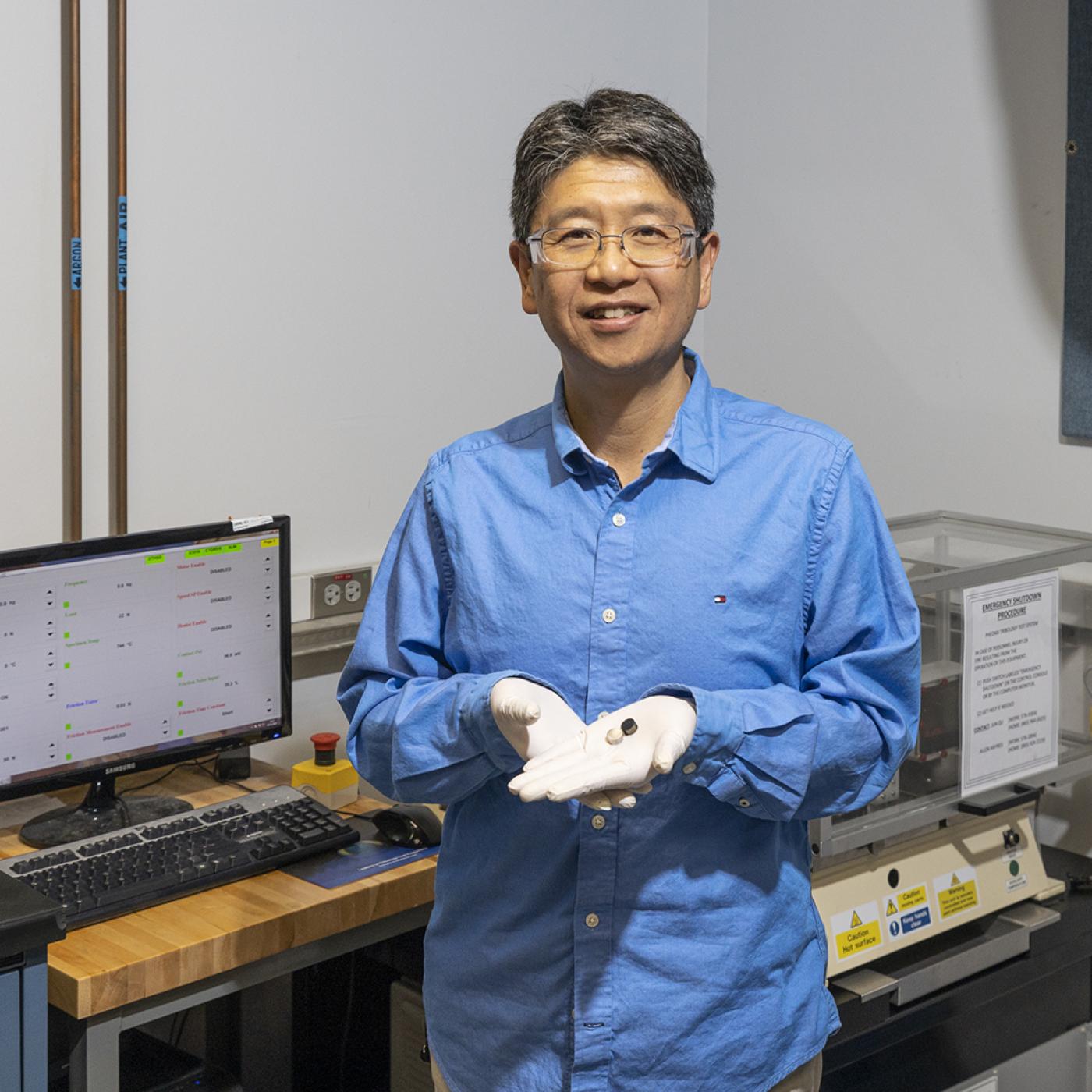 Jun Qu of ORNL shows stainless-steel disks