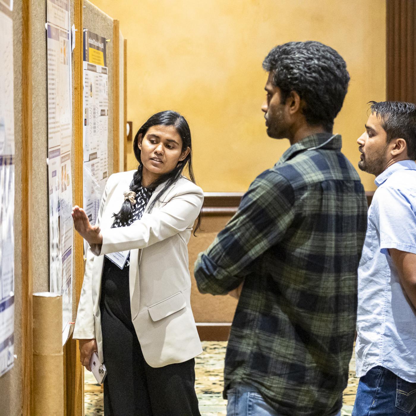 Chathuddasie Amarasinghe explains her research poster, “Using Microfluidic Mother Machine Devices to Study the Correlated Dynamics of Ribosomes and Chromosomes in Escherichia Coli.” Credit: Carlos Jones/ORNL, U.S. Dept. of Energy